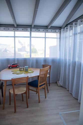 a dining room with a table and chairs and a window at T2 terrasse de charme à Rochebonne 400 m plage in Saint Malo