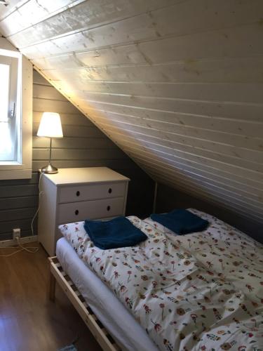 a bedroom with a bed with blue pillows on it at Domki nad morzem Sasino Mojo Miodno Checz in Sasino