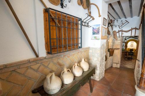a group of vases sitting on a bench in a room at APAR. SIERRAGUADALQUIVIR in Quesada