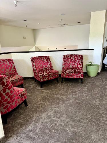 a waiting room with two red chairs and a green bowl at Rodeway Inn Boise Airport in Boise