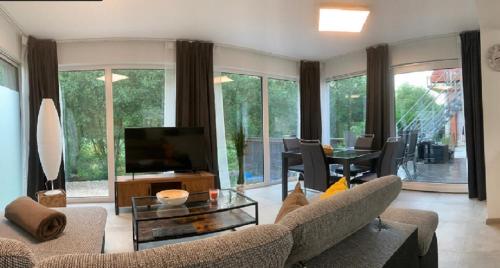 ein Wohnzimmer mit einem Sofa und einem TV in der Unterkunft Firmen & Ferienwohnung Brecht 2 in Waibstadt