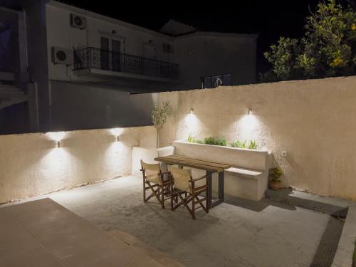 a table and two chairs on a patio at night at House of Hats II in Karavomylos