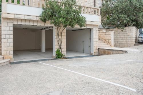 two garage doors with a tree in a parking lot at Vila Marina Sea&City View in Makarska