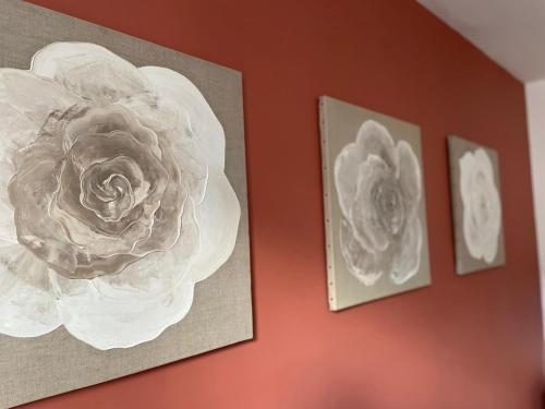 two pictures of flowers are hanging on a wall at Le W - Appart vintage in Épernay