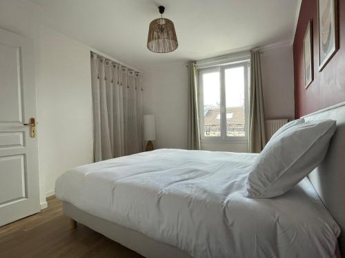 a bedroom with a white bed and a window at Le W - Appart vintage in Épernay