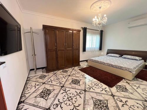 a bedroom with a bed and a chandelier at APARTMENT AYOUB -for families only- in Nador