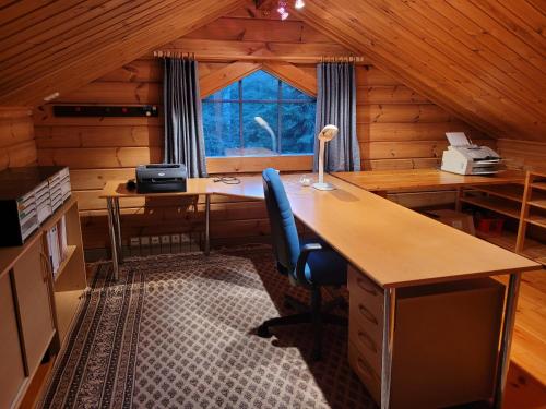 una oficina con dos escritorios y una ventana en una cabaña en Lakeland Karelia Puutikka, en Kesälahti