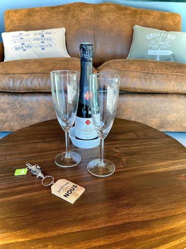 - une table avec 2 verres et une bouteille de vin dans l'établissement Adorable Guest House avec balnéo et piscine, à Olonne-sur-Mer
