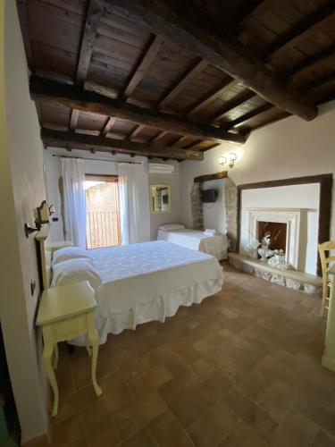 een slaapkamer met een groot bed en een open haard bij Relais Il Monaco in Artena