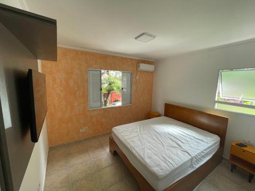 a bedroom with a bed and a flat screen tv at Lar Doce Lar Toque Toque Grande in São Sebastião