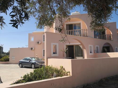 ein Haus mit einem davor geparkt in der Unterkunft Seashell Apartments in Paphos City