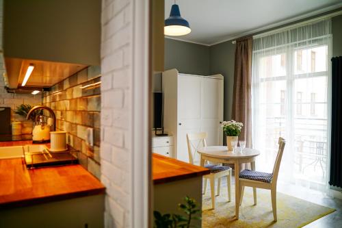 a kitchen with a table and a dining room at Apartament Ohar Downtown in Elblag
