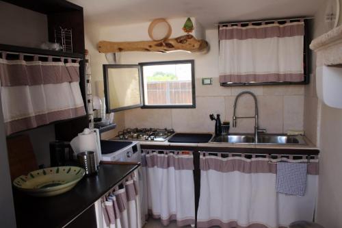 eine kleine Küche mit einer Spüle und einem Herd in der Unterkunft Trullo Titti in Ostuni