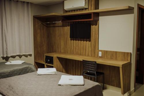 a hotel room with two beds and a television at MANANCIAL HOTEL E EVENTOS in Manhuaçu