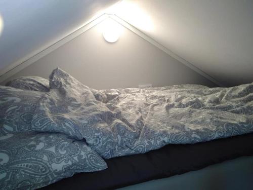 een ongemaakt bed in een kamer met een licht bij Attefallshus byggt 2019 in Helsingborg
