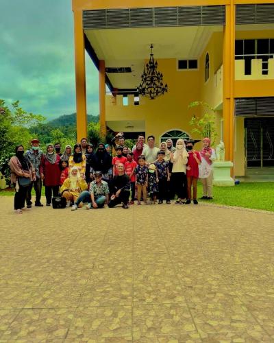 a group of people posing for a picture in front of a building at Homestay Seri Pangkor in Pangkor