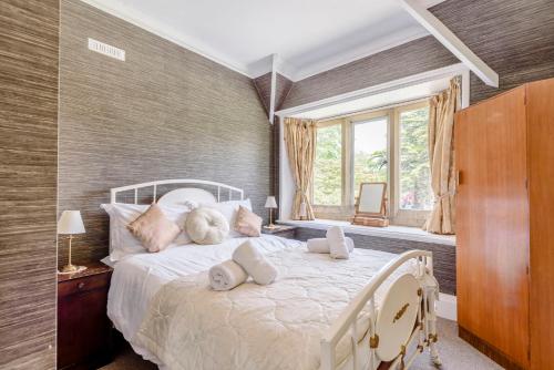 a bedroom with a large white bed with pillows at Plas Gwynfryn in Llanbedr