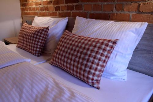 two pillows are sitting on a bed next to a brick wall at Noclegi Złota Podkowa in Olszowa