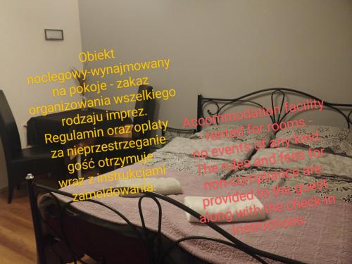 Un dormitorio con una cama con palabras. en Smolna 9 WARSZAWA CENTRUM, en Varsovia