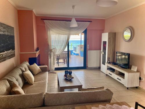 a living room with a couch and a tv at Villa Porto Thassos in Limenas