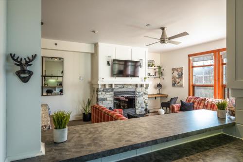 a living room with a table and a fireplace at Le Serein Condo Tremblant Les-Eaux in Mont-Tremblant
