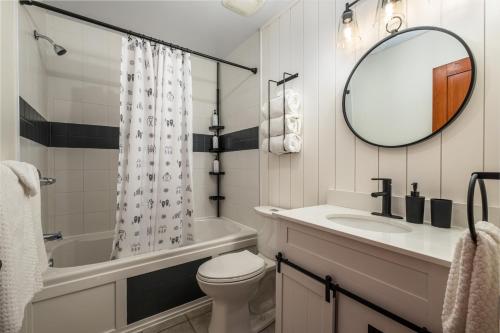 een badkamer met een wastafel, een toilet en een spiegel bij Le Serein Condo 1 chambre à Tremblant Les-Eaux in Mont-Tremblant