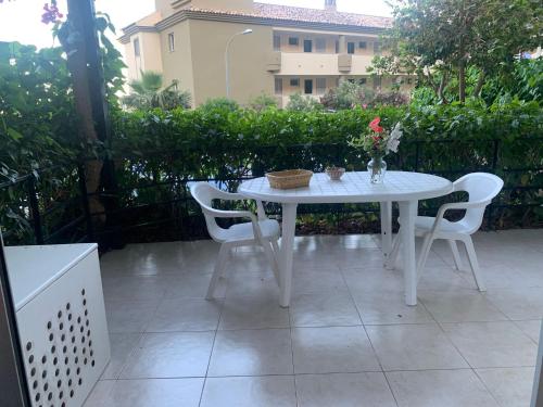 - une table et des chaises blanches sur la terrasse dans l'établissement NEW Tranquilo apartamento a un paso de la playa y del centro, à Torremolinos