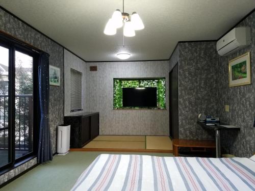 1 dormitorio con 1 cama y TV en la pared en Bibi Vacation Rental Only 2 groups per day Vacation STAY 1284 en Sakai