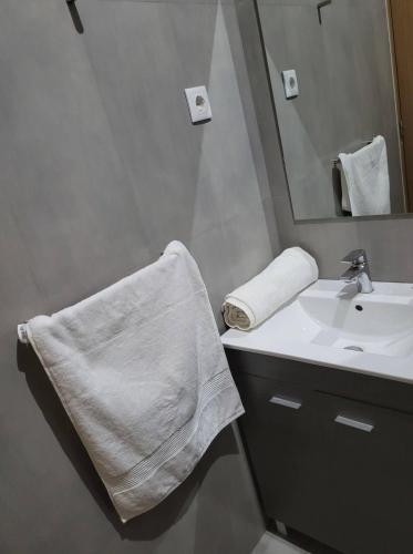 a white bathroom with a sink and a mirror at ENZO APARTAMENTO T0 in Espargos