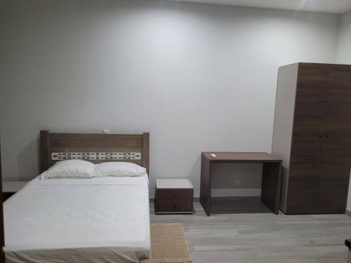 um quarto com uma cama, uma mesa de cabeceira e uma mesa em ENZO APARTAMENTO T0 em Espargos