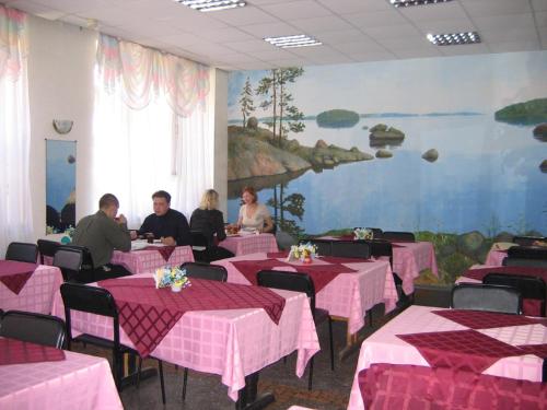 un grupo de personas sentadas en mesas en un restaurante en Karelrepostrebsoyuz Hostel, en Petrozavodsk