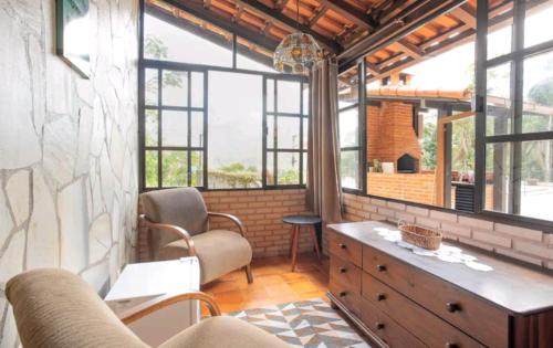 a living room with a couch and a table and windows at Hotel Boutique Pé Da Tartaruga in Teresópolis