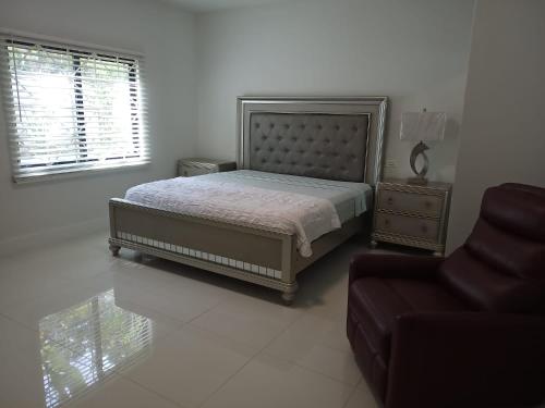 a bedroom with a bed and a couch and a chair at Luxury 2 Bedroom Rooftop pool View unit #3 in Falmouth