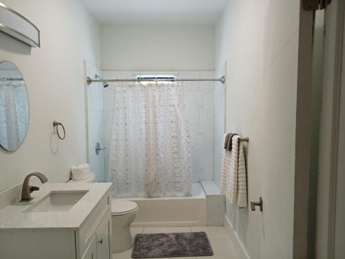 Baño blanco con lavabo y aseo en Luxury 2 Bedroom Rooftop pool View unit #3, en Falmouth