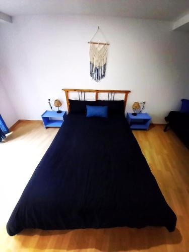 a large bed in a room with blue tables at Cornukarma Apartamiento La Capella in Cornudella