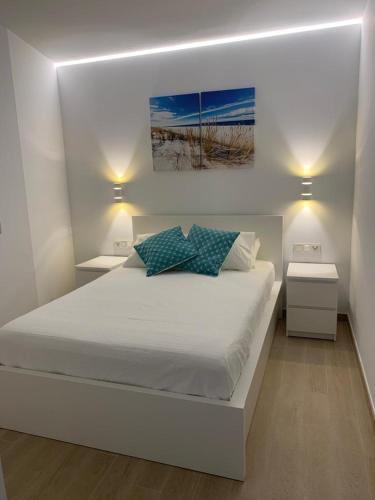 ein Schlafzimmer mit einem großen weißen Bett mit zwei Nachttischen in der Unterkunft Bonito apartamento Carvajal - Fuengirola - The Wave in Fuengirola