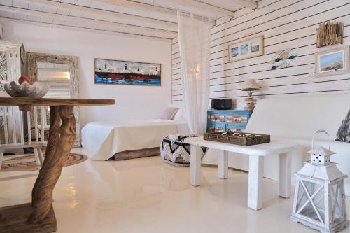 a white living room with a bed and a table at Amelia Private Pool Apartment in Panormos Mykonos