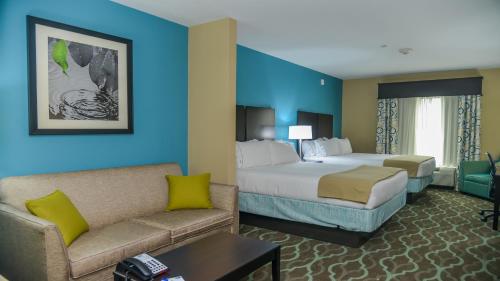 a hotel room with two beds and a couch at Holiday Inn Express Hotels & Suites Cuero, an IHG Hotel in Cuero