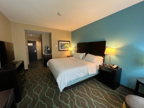 a hotel room with a bed and two night stands at Holiday Inn Express Hotels & Suites Cuero by IHG in Cuero