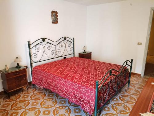 a bedroom with a bed with a red bedspread at Casa vacanze zaccanopoli in Zaccanopoli