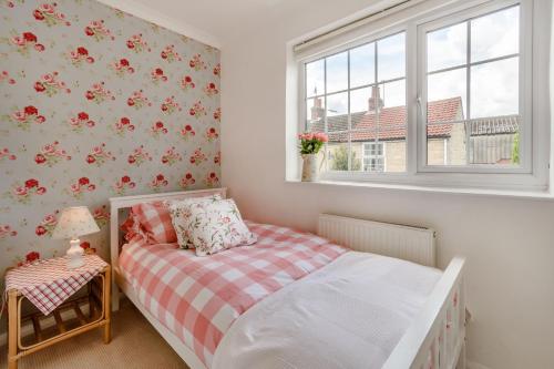 A bed or beds in a room at Snowdrop Cottage