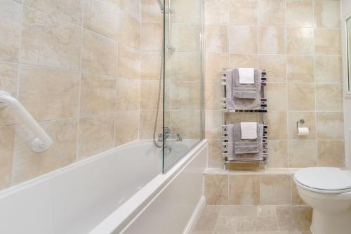 uma casa de banho com uma banheira, um WC e um chuveiro em Snowdrop Cottage em Wetherby