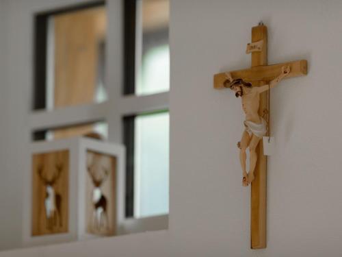 a wooden cross hanging on a wall with mirrors at Chalet Windbach in Saalbach Hinterglemm