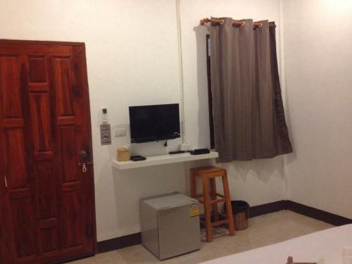 a room with a television sitting on a shelf next to a door at Space Ben Guest House @ Muangkao in Sukhothai