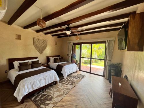 een slaapkamer met 2 bedden en een groot raam bij Villa Marcela in Calderitas