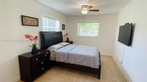 a bedroom with a bed and a ceiling fan at El Shaddai Faithfully Beach in Hollywood