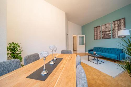 ein Wohnzimmer mit einem Tisch und einem blauen Sofa in der Unterkunft Stilvolle FeWo Augusta I in Görlitz