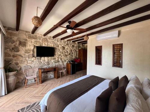 a bedroom with a bed and a stone wall at Villa Marcela in Calderitas