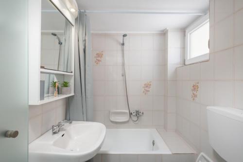 Rooftop Cosy Apartment Perfect Location في مدينة هيراكيلون: حمام أبيض مع حوض ودش