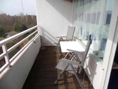 a balcony with two chairs and a desk at Ferienpark Sierksdorf App 773 - Strandlage in Sierksdorf